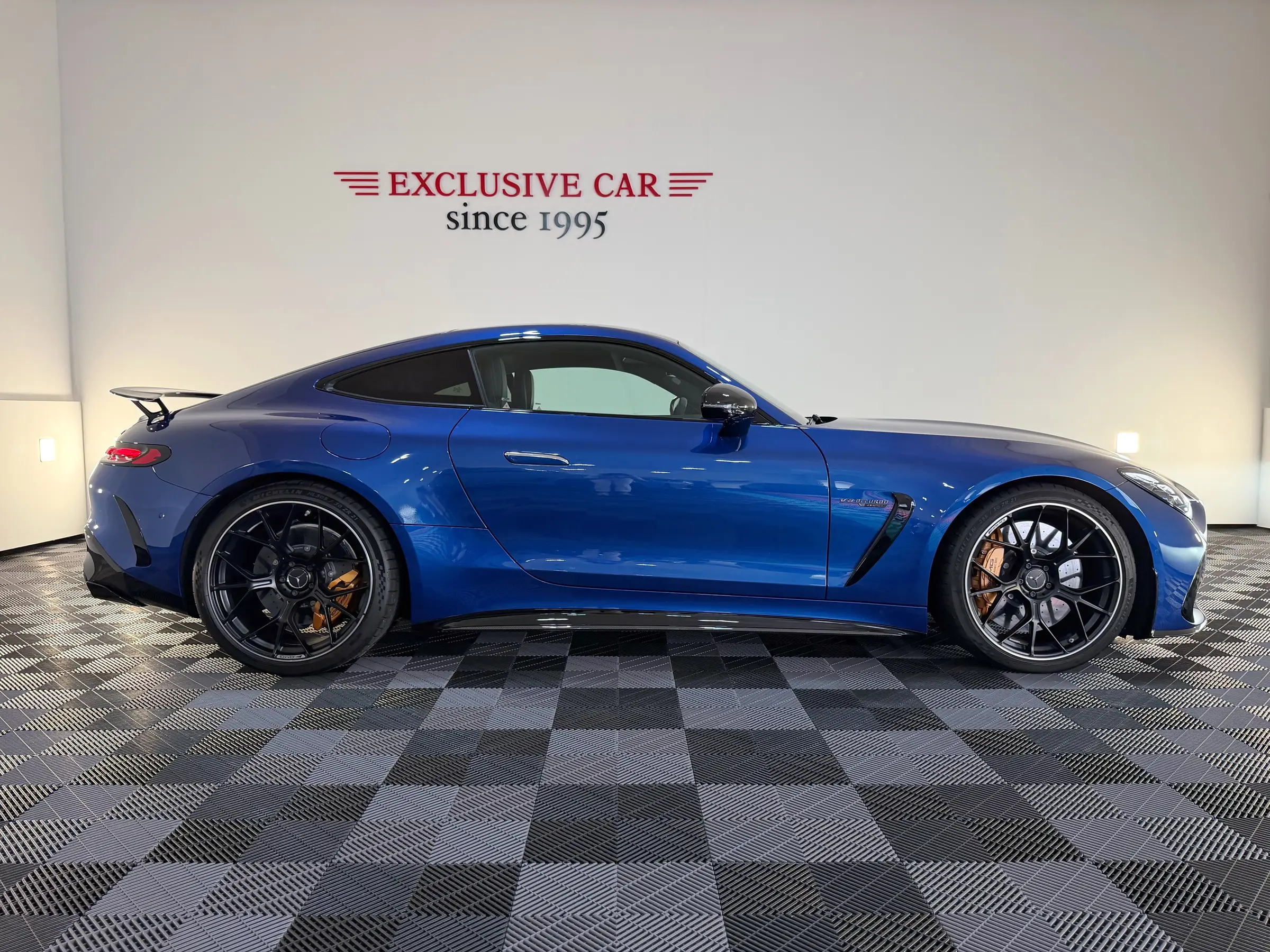 Modrý Mercedes-AMG GT z boku v showroomu Exclusive Car
